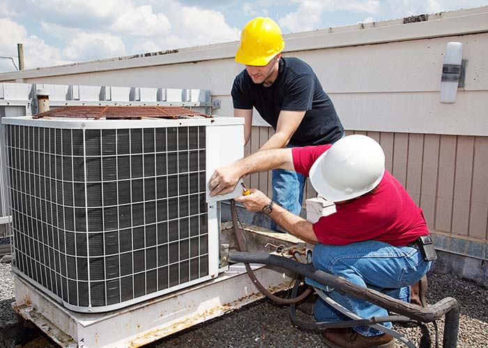 HVAC system technician performing maintenance in Texas heat